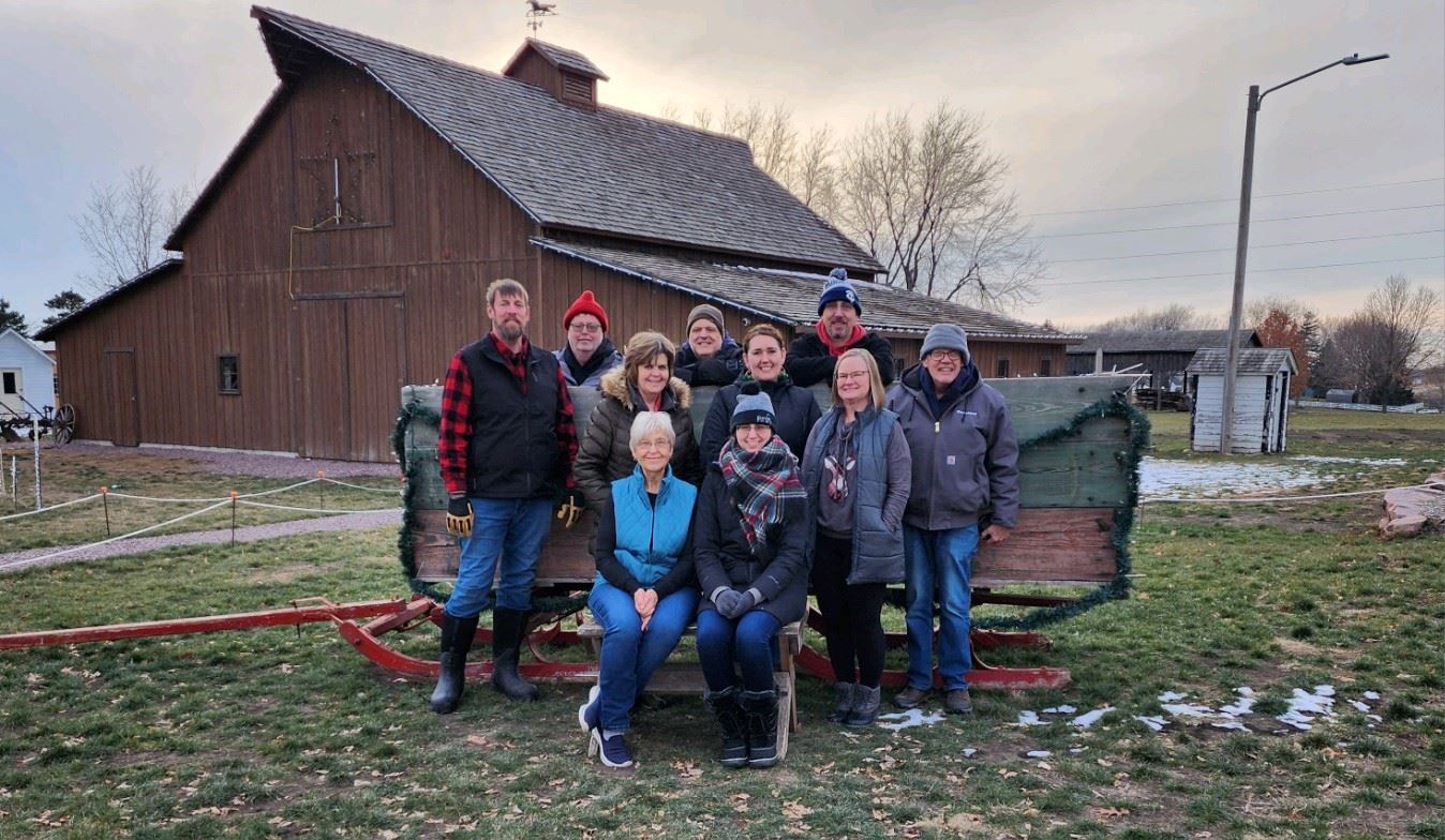 Group of people by wooden barn